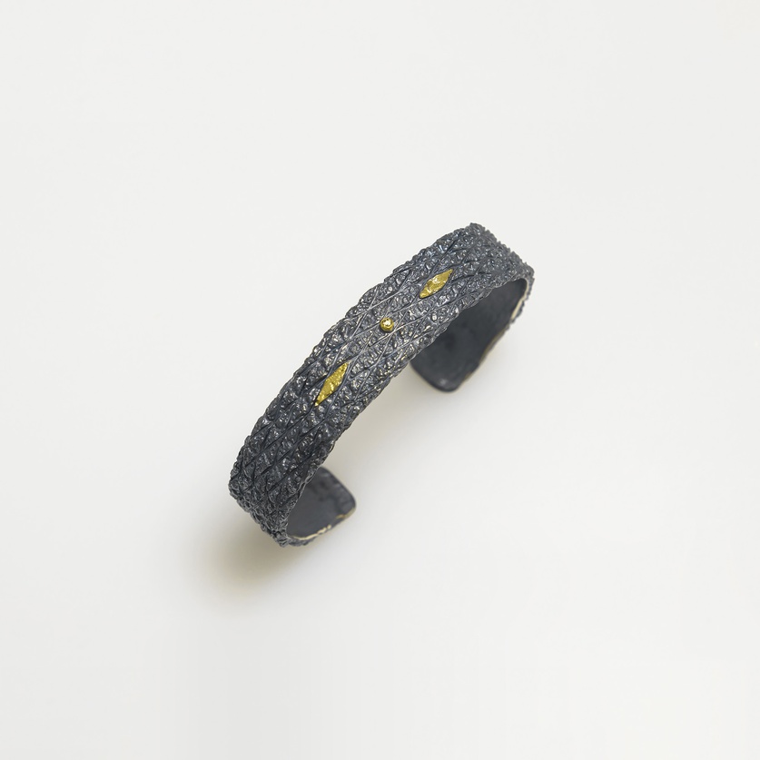 Silver bracelet of intricate detail with gold and diamond
