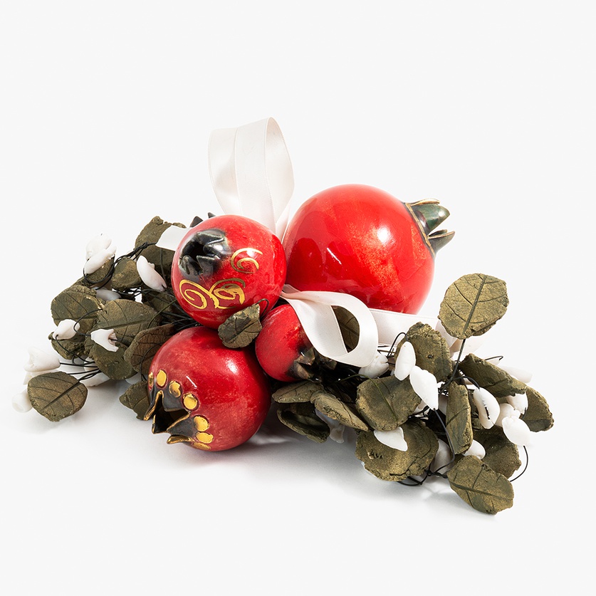 Festive composition with pomegranates and green leaves